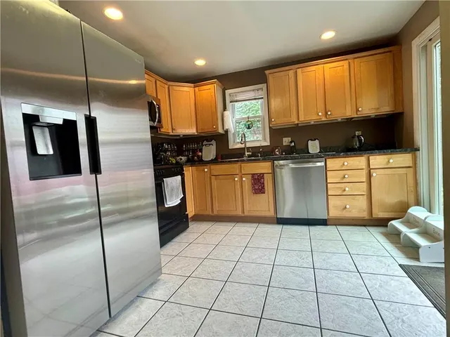 a kitchen with stainless steel appliances granite countertop a refrigerator and a sink
