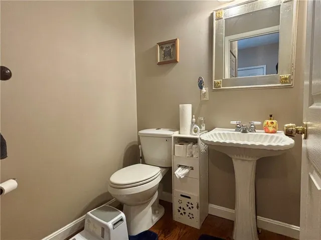 a bathroom with a toilet sink and mirror