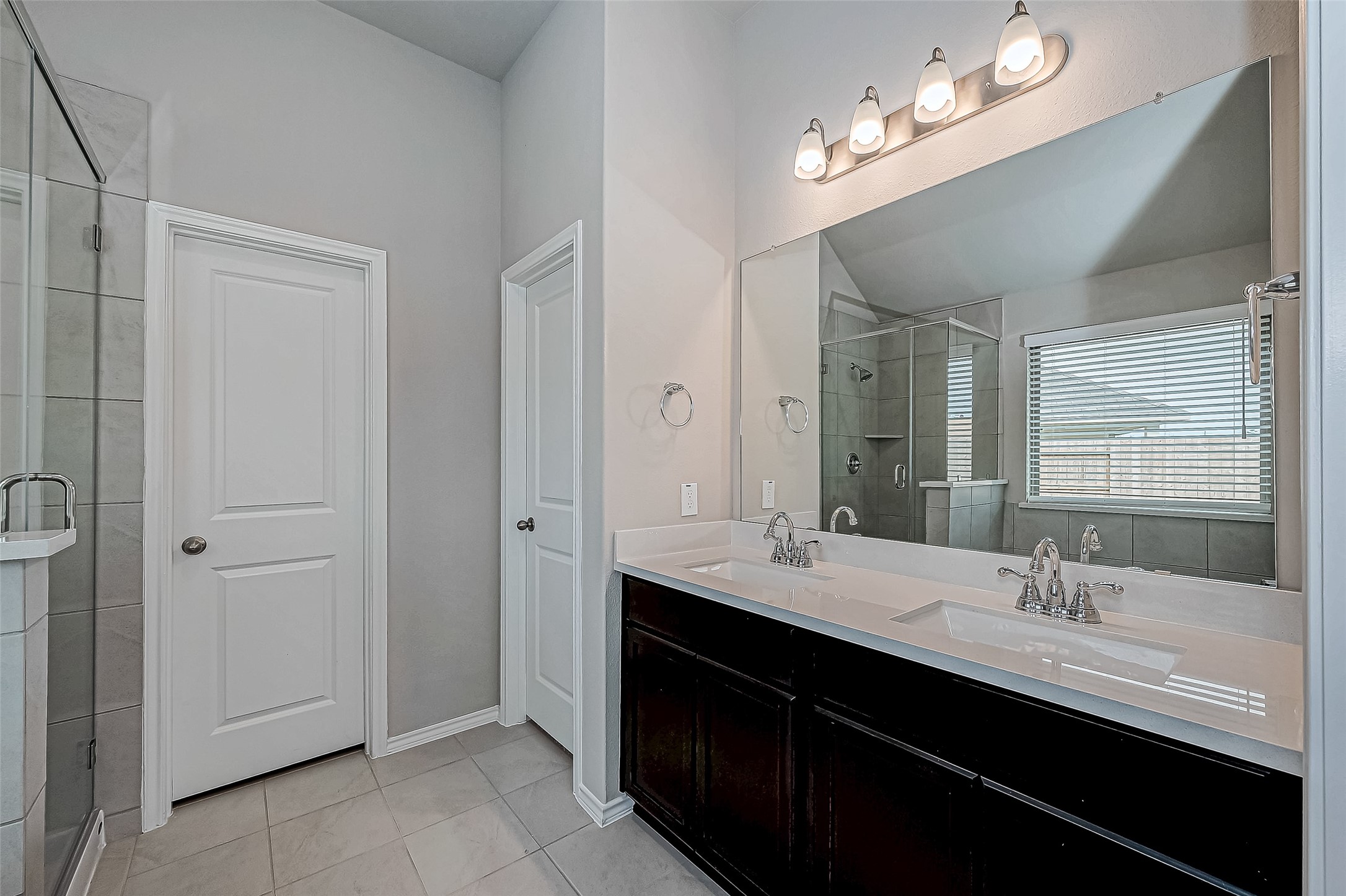 31801 Pecan Cottage Lane Spring, TX 77386 - Photo 27 of 37 a bathroom with double vanity sinks a vanity a lamp and a mirror
