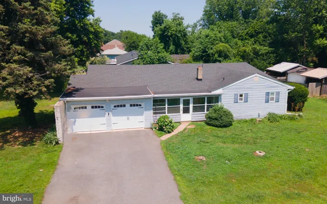 a aerial view of a house with yard and green space