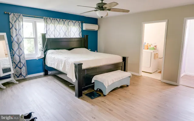 a spacious bedroom with a bed and a chandelier