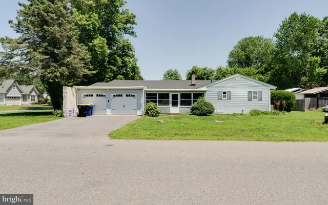 a front view of a house with a garden and trees