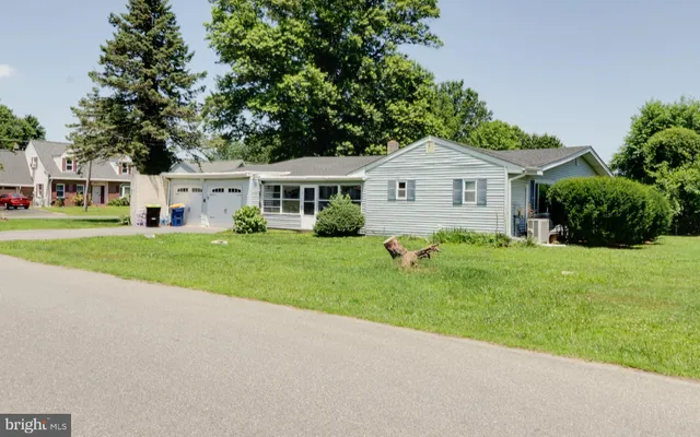 a view of a house with a yard and large trees