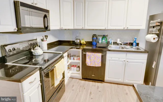 a kitchen with a stove and white cabinets