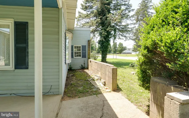 a view of a white house with large windows and plants