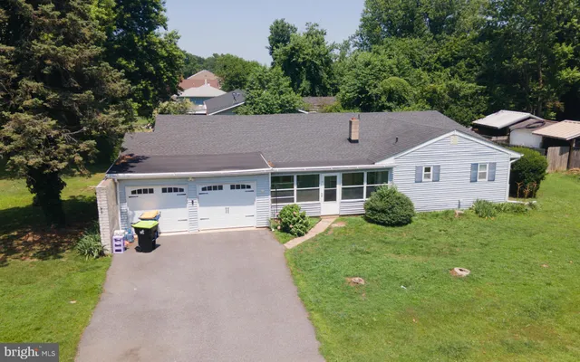 aerial view of a house with a yard and lake view