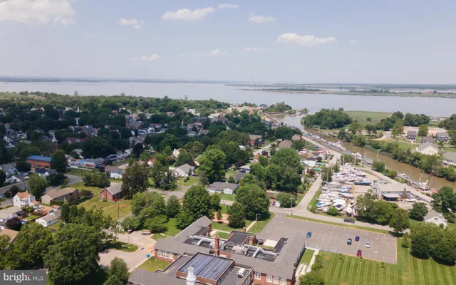 a sign board with a big yard and large trees
