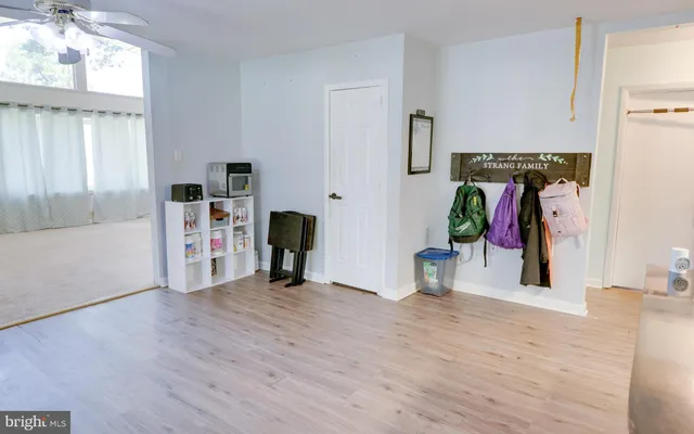 a view of a livingroom with wooden floor and a ceiling fan