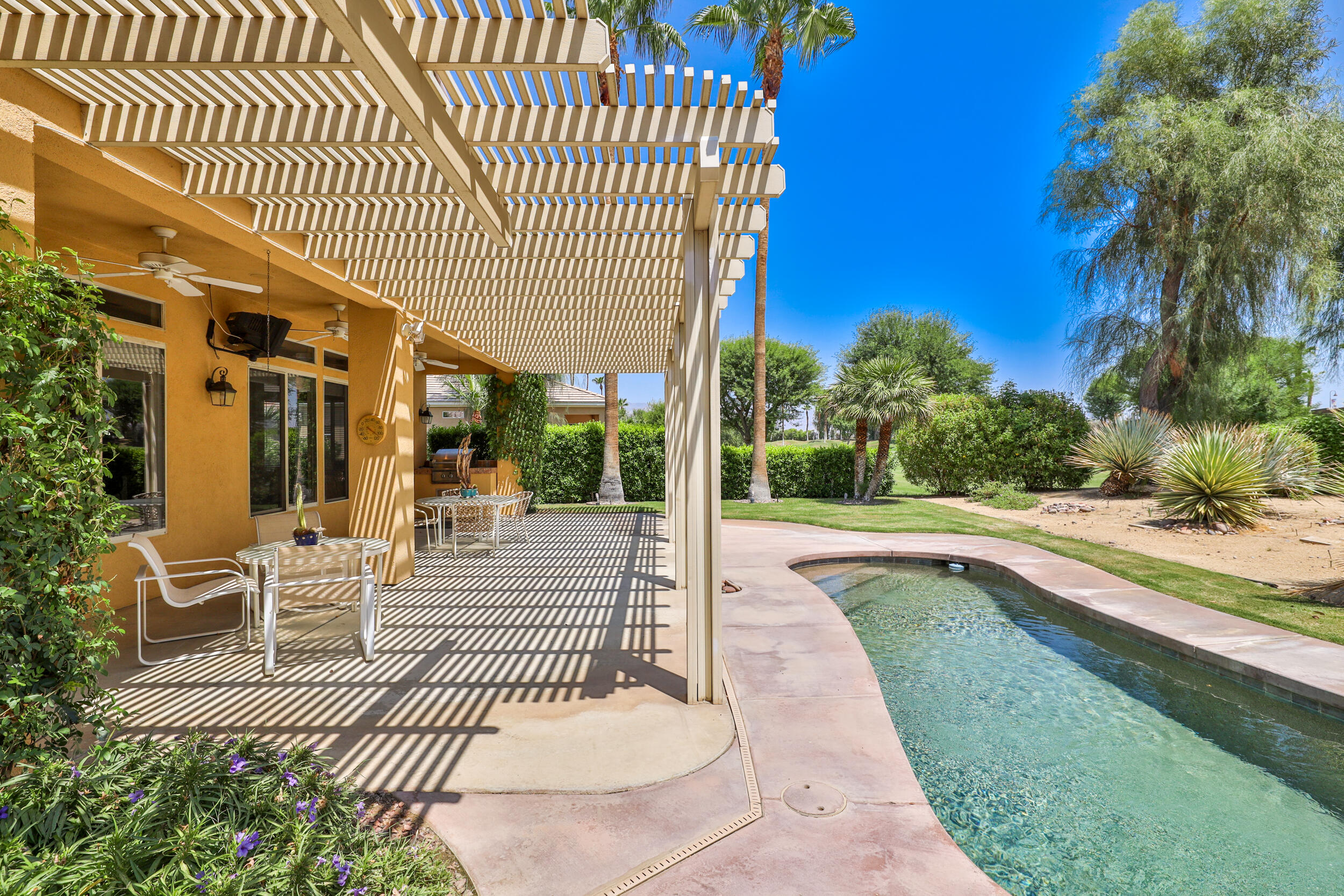 44410 Royal Lytham Drive Indio, CA 92201 - Photo 37 of 72 a view of a patio with dining table and chairs with wooden floor