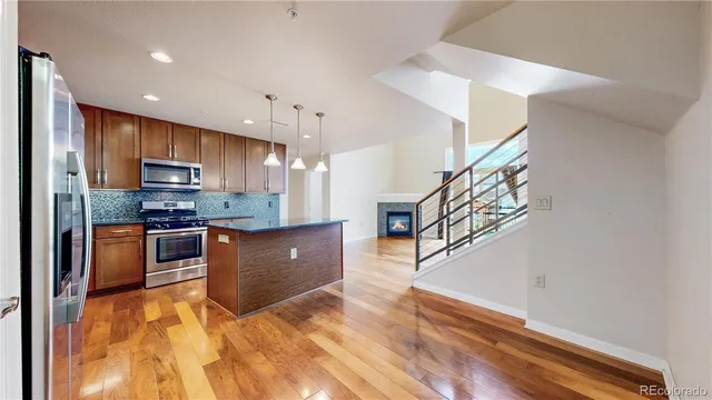 a kitchen with stainless steel appliances granite countertop a refrigerator a stove top oven a sink and dishwasher