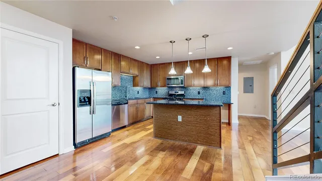 a kitchen with stainless steel appliances granite countertop a refrigerator and a sink