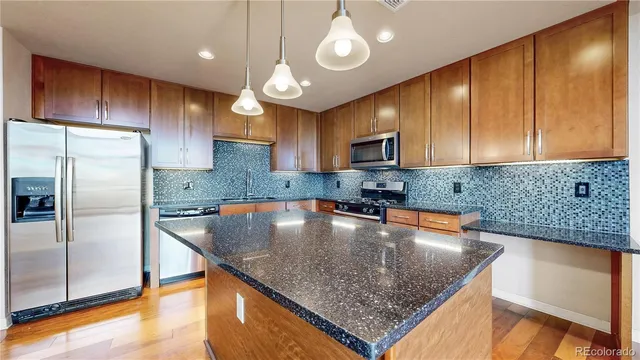 a kitchen with stainless steel appliances granite countertop a sink a microwave cabinets and a counter top space