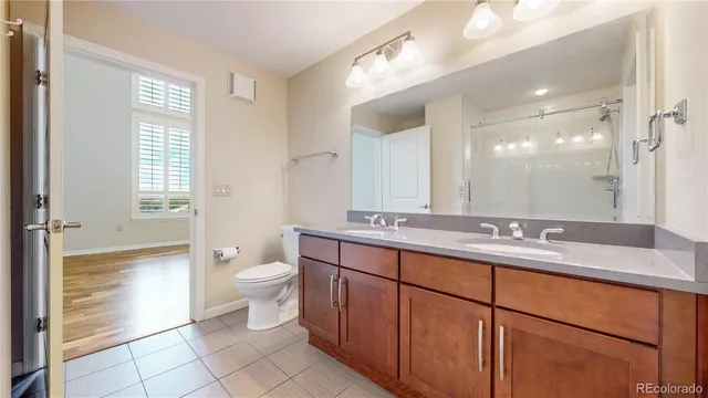 a bathroom with a double vanity sink toilet and a tub