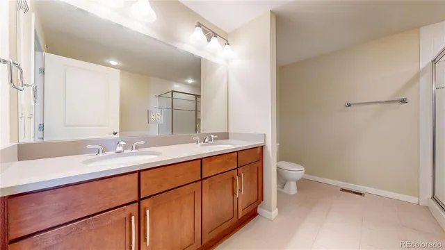a bathroom with a double vanity sink toilet and mirror