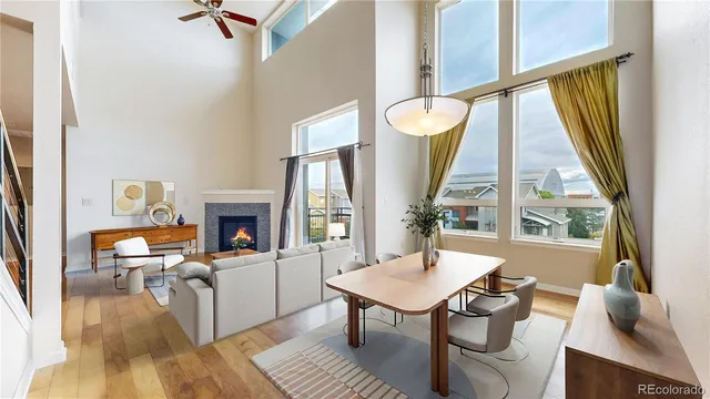 a living room with furniture a fireplace and large windows