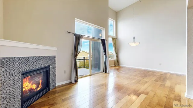 a view of empty room with wooden floor and fireplace