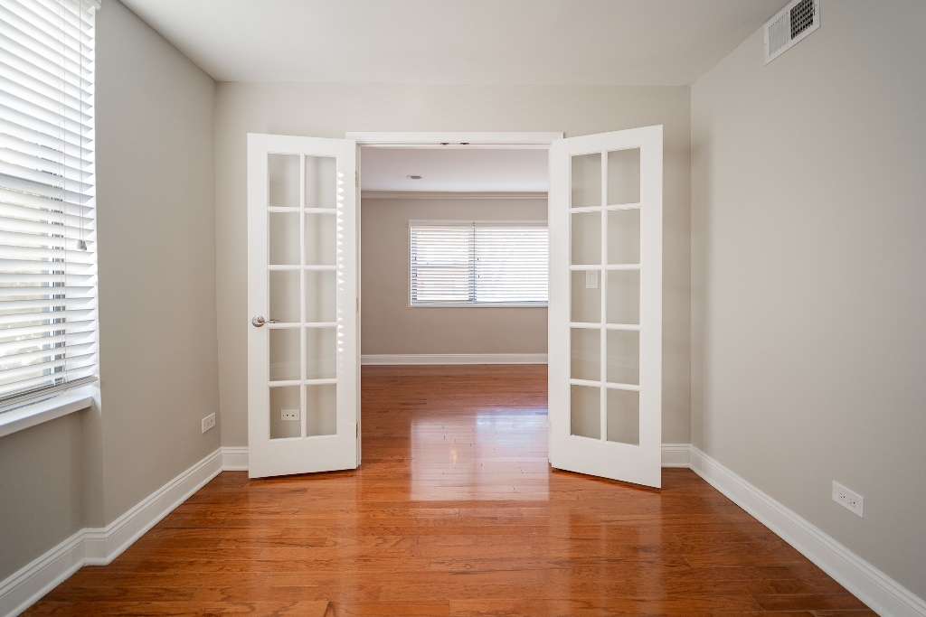515 Sheridan Road, Unit 101 Evanston, IL 60202 - Photo 11 of 18 an empty room with wooden floor and windows