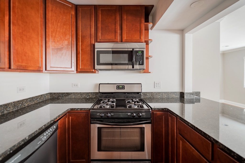 515 Sheridan Road, Unit 101 Evanston, IL 60202 - Photo 18 of 18 a kitchen with granite countertop a stove sink and cabinets