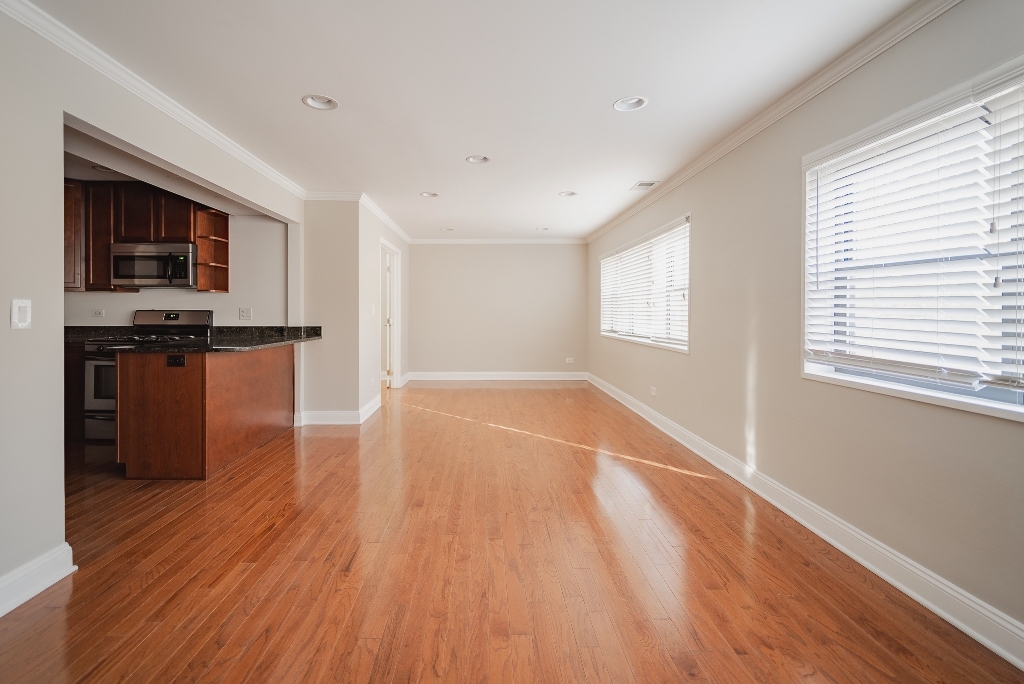 515 Sheridan Road, Unit 101 Evanston, IL 60202 - Photo 4 of 18 wooden floor in an empty room with a window