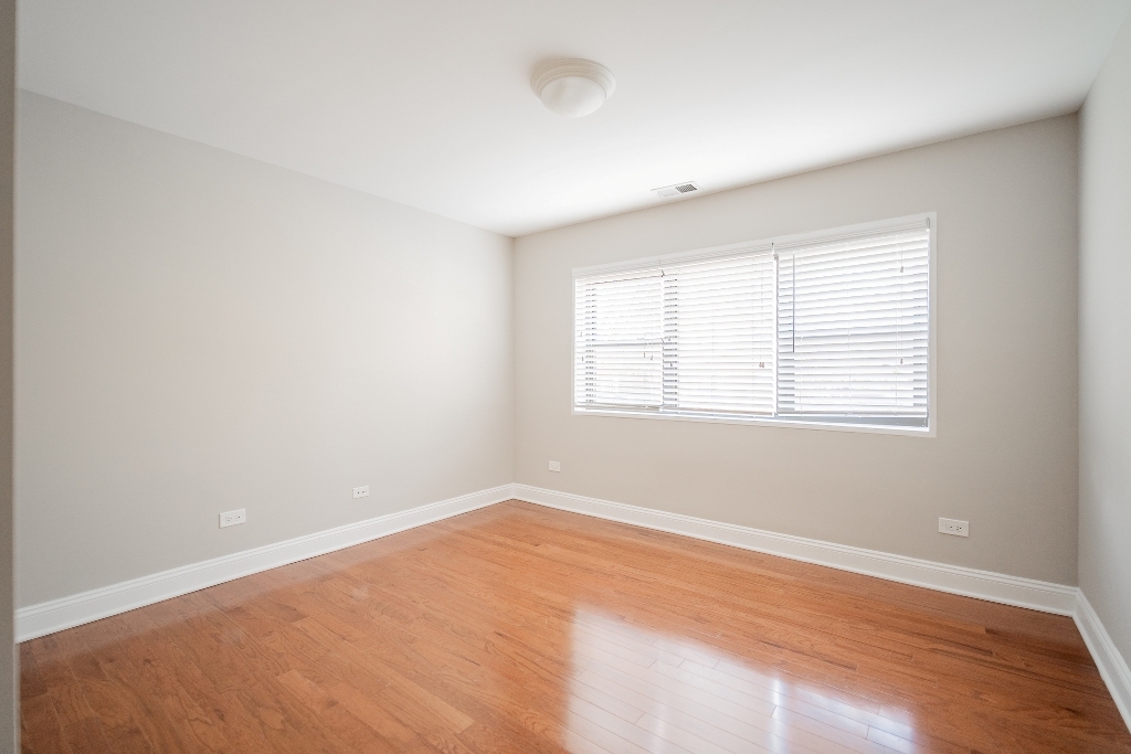 515 Sheridan Road, Unit 101 Evanston, IL 60202 - Photo 9 of 18 an empty room with wooden floor and windows