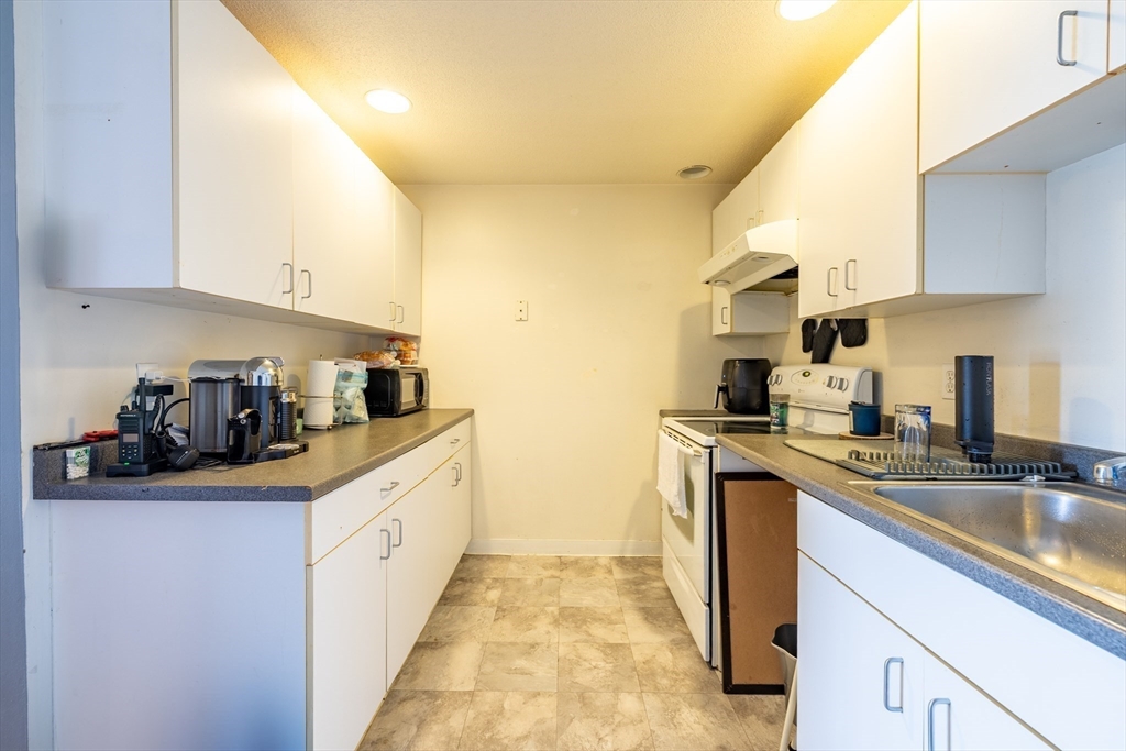 336 Adams Street, Unit 22 Boston, MA 02122 - Photo 7 of 9 a kitchen with stainless steel appliances granite countertop a sink and cabinets