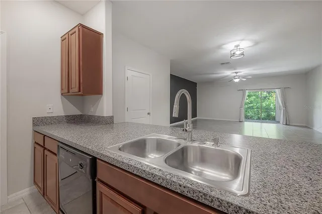 a kitchen with granite countertop wood cabinets and a stove top oven