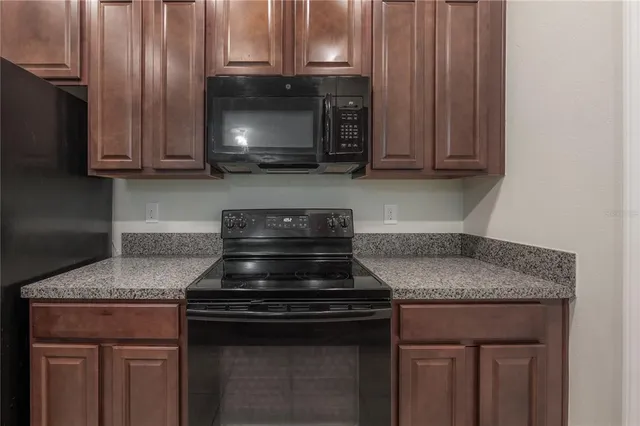 a kitchen with granite countertop a sink and a stove