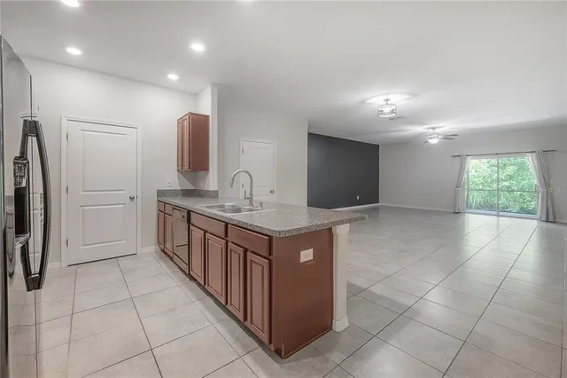a kitchen with stainless steel appliances granite countertop a sink and a refrigerator