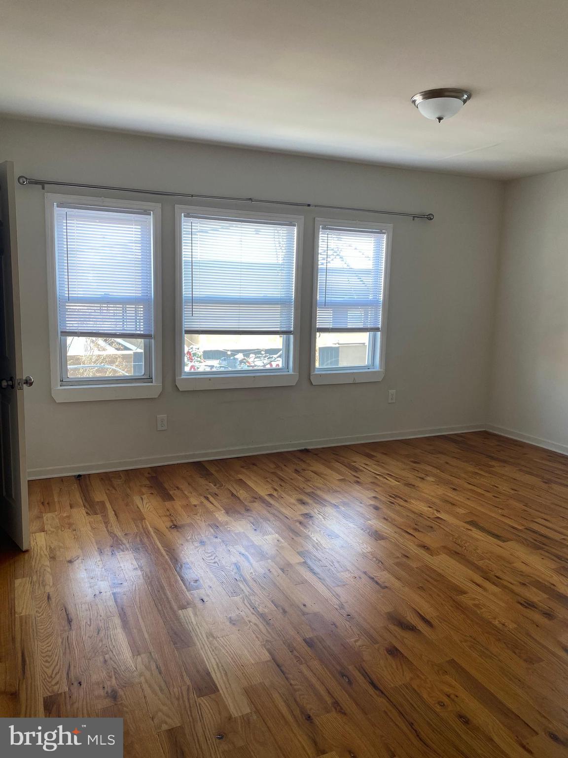 58 South Broadway, Unit 58C Pitman, NJ 08071 - Photo 31 of 35 an empty room with wooden floor and windows