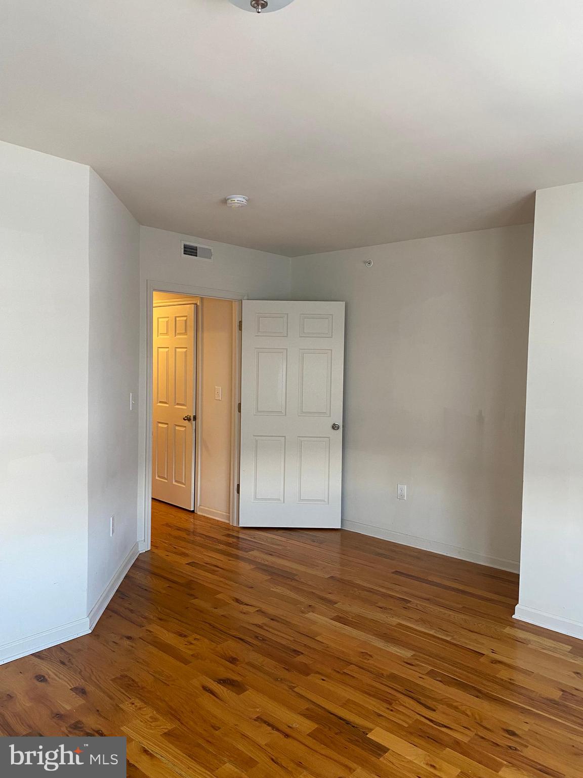 58 South Broadway, Unit 58C Pitman, NJ 08071 - Photo 34 of 35 a view of an empty room with wooden floor and a window