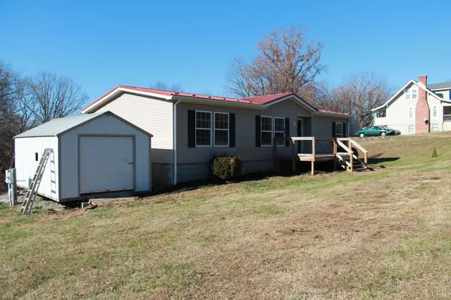 a view of a house with a yard and wooden fence