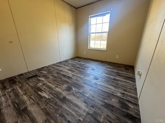 a view of a room with wooden floor and window