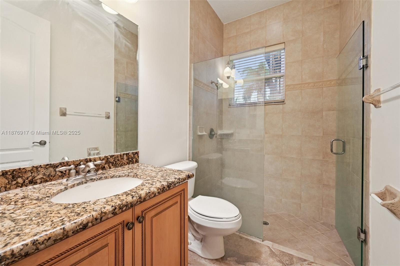 9192 Nugent Trail West Palm Beach, FL 33411 - Photo 31 of 62 a bathroom with a granite countertop sink toilet and shower