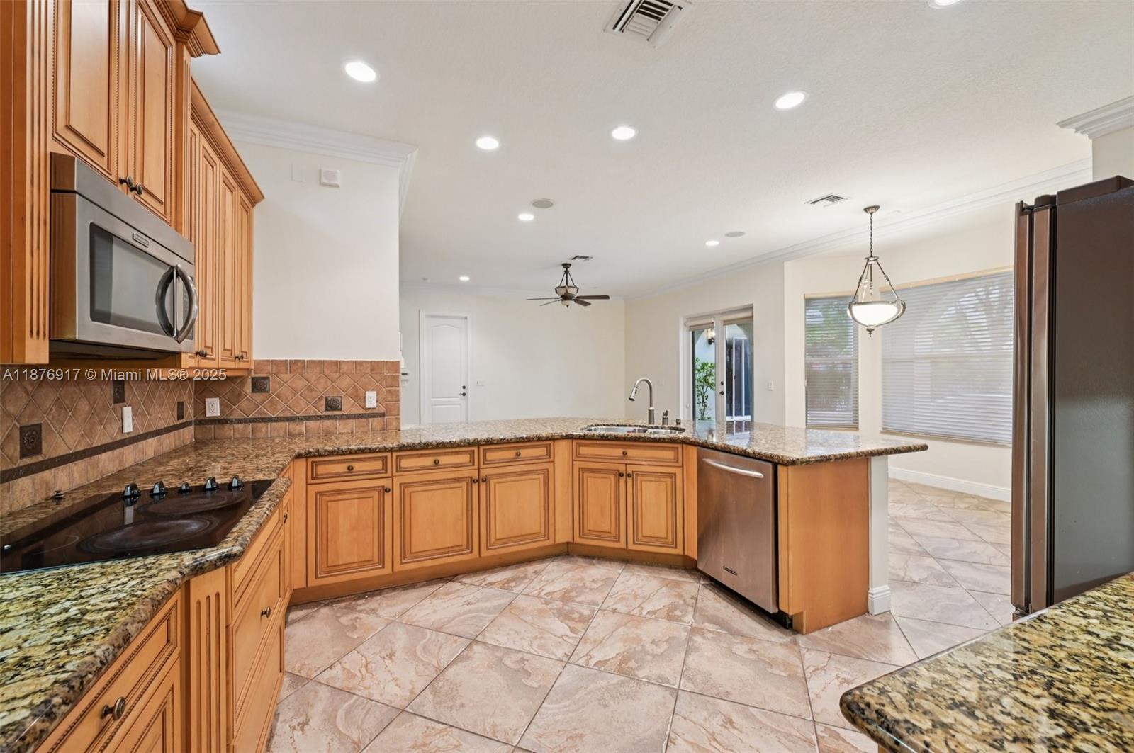 9192 Nugent Trail West Palm Beach, FL 33411 - Photo 7 of 62 a kitchen with stainless steel appliances granite countertop a stove a sink and a refrigerator