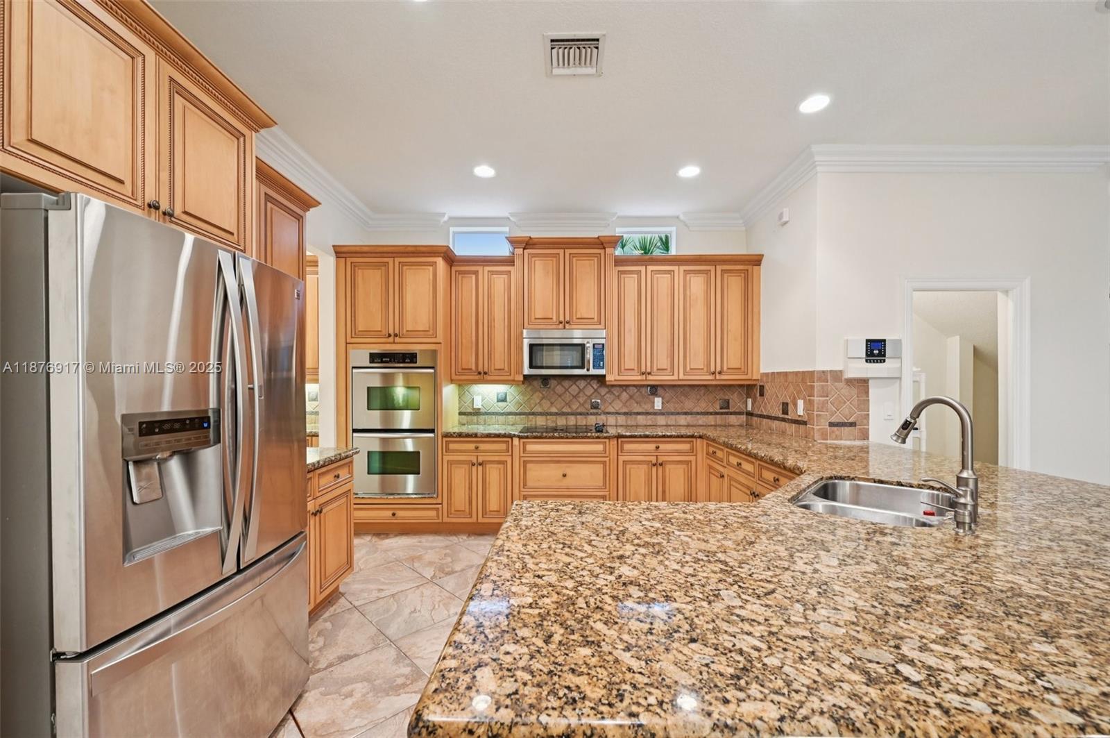 9192 Nugent Trail West Palm Beach, FL 33411 - Photo 8 of 62 a kitchen with stainless steel appliances granite countertop a refrigerator sink and cabinets
