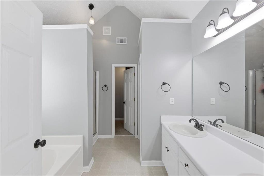493 Youth Jersey Road Covington, GA 30014 - Photo 30 of 52 a bathroom with a tub sink double vanity and a mirror