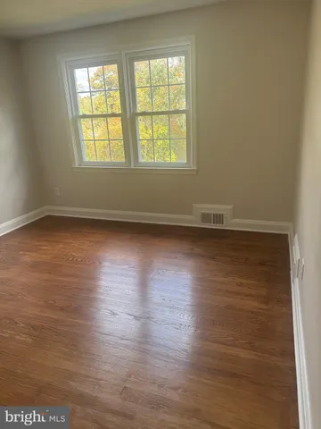 an empty room with wooden floor and closet