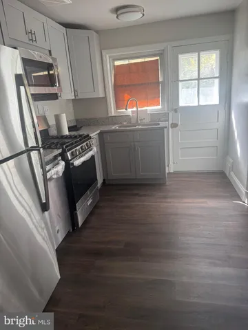 a kitchen with granite countertop a refrigerator and a stove