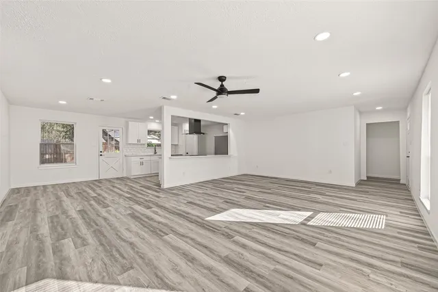 a large white kitchen with kitchen island a sink stainless steel appliances and cabinets