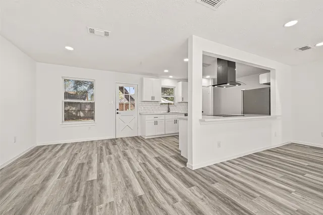 a kitchen with stainless steel appliances white cabinets and wooden floor