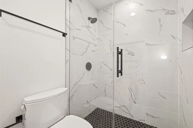 a backyard of a house with large trees and a wooden fence