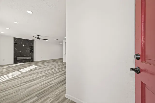 an empty room with wooden floor and windows