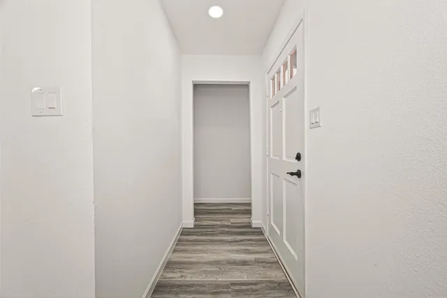 a view of empty room with wooden floor and window