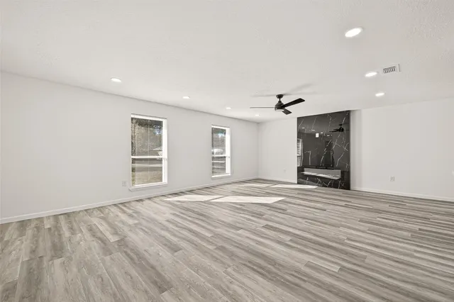a view of empty room with wooden floor