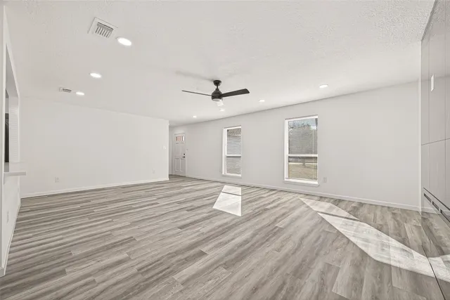 a view of a kitchen with wooden floor and electronic appliances