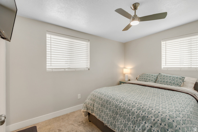 48 Moon Ridge Drive Murray, UT 84107 - Photo 12 of 30 Primary bedroom featuring a ceiling fan with integrated lighting, two windows with horizontal blinds, and carpeting