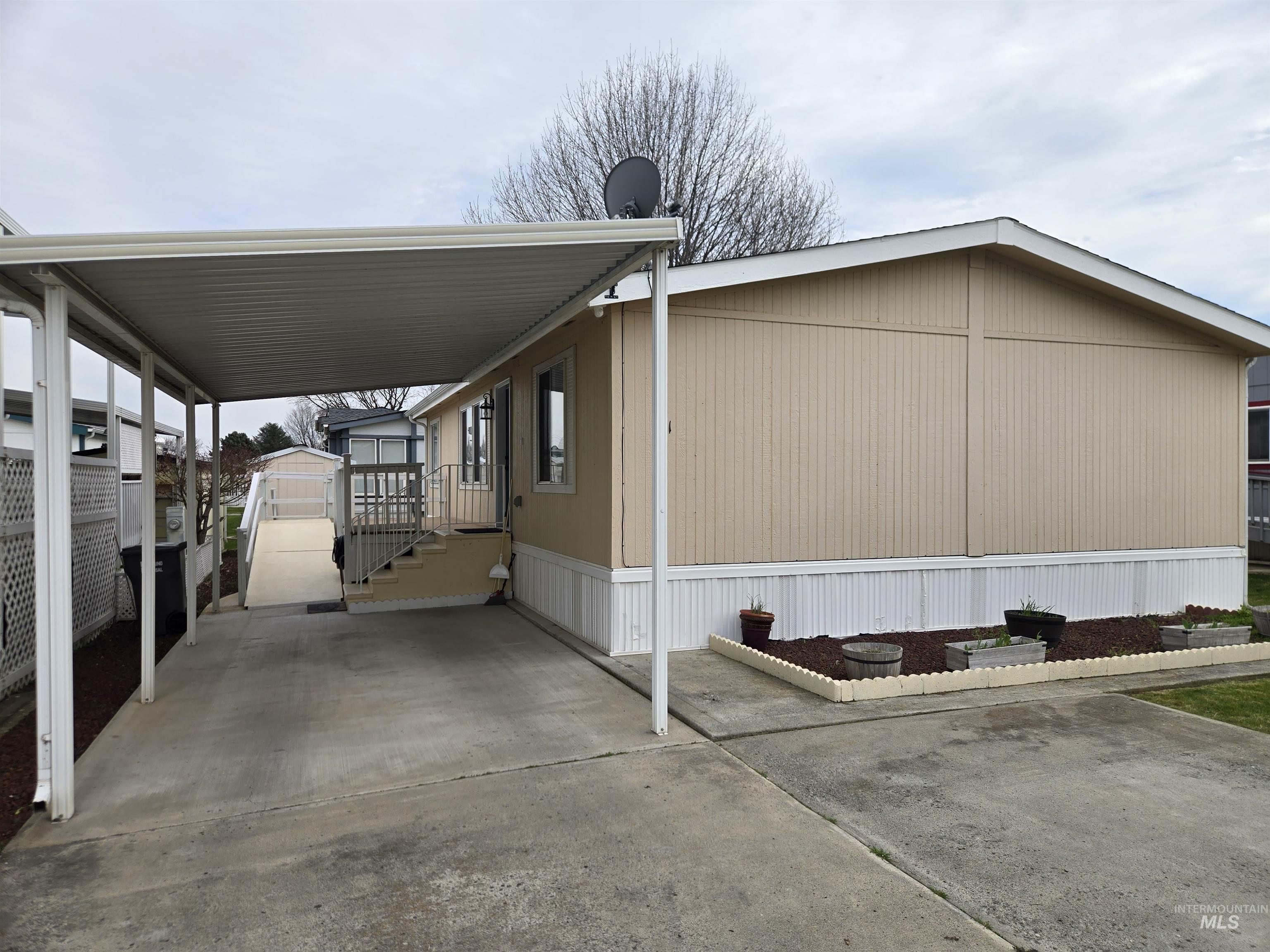 2115 6th Avenue, Unit 51 Clarkston, WA 99403 - Photo 2 of 34 View of side of home with an attached carport, an outdoor structure, and a porch
