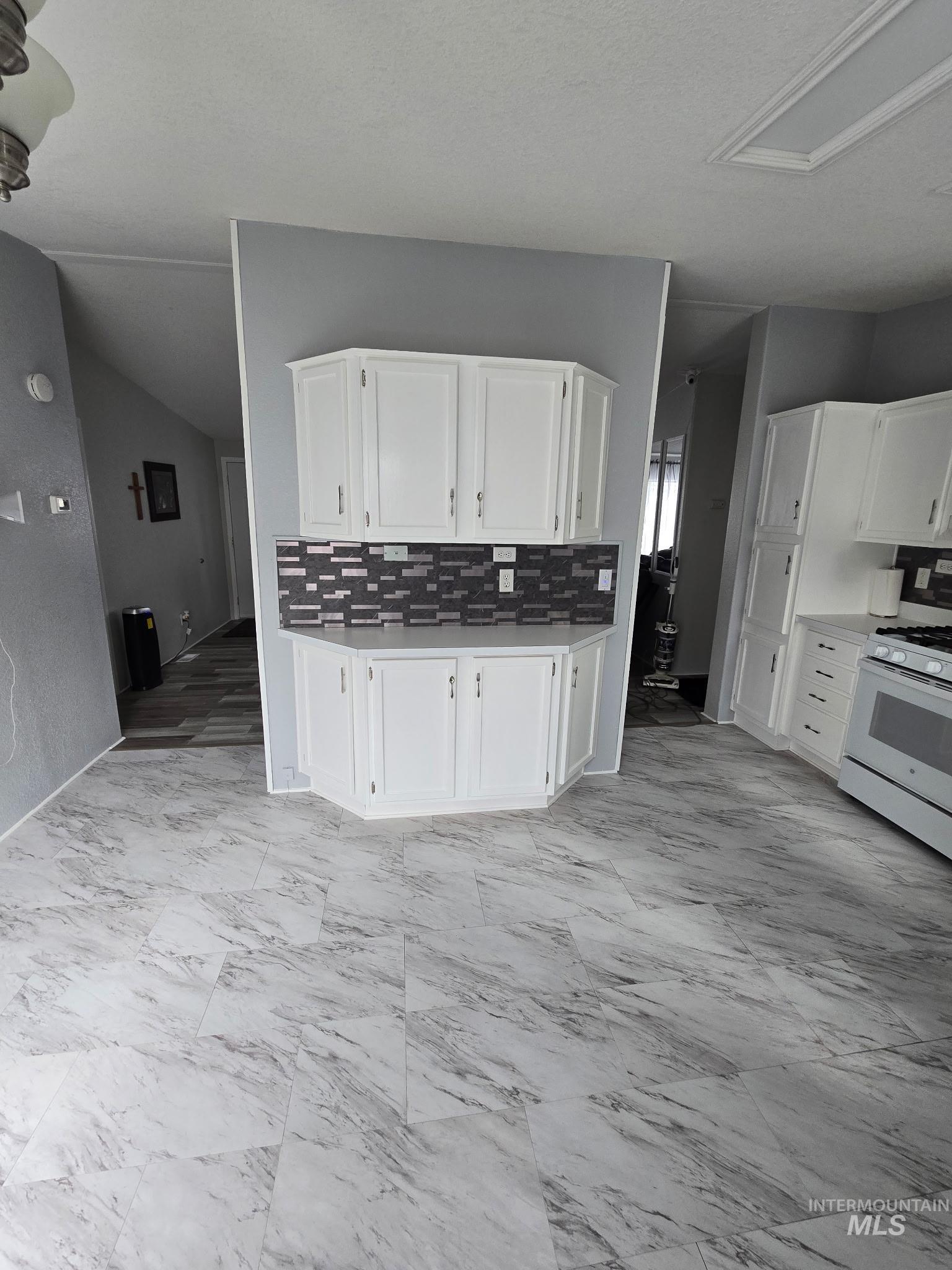 2115 6th Avenue, Unit 51 Clarkston, WA 99403 - Photo 27 of 34 Kitchen with white cabinetry, white range with gas cooktop, light marble finish flooring, and light countertops