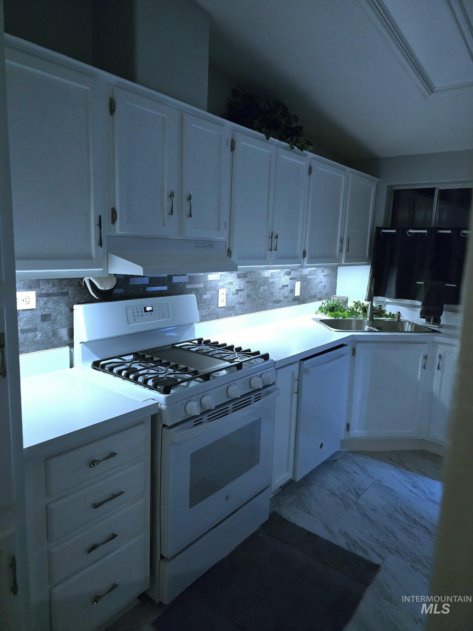 2115 6th Avenue, Unit 51 Clarkston, WA 99403 - Photo 6 of 34 Kitchen with white appliances, white cabinetry, light countertops, and backsplash