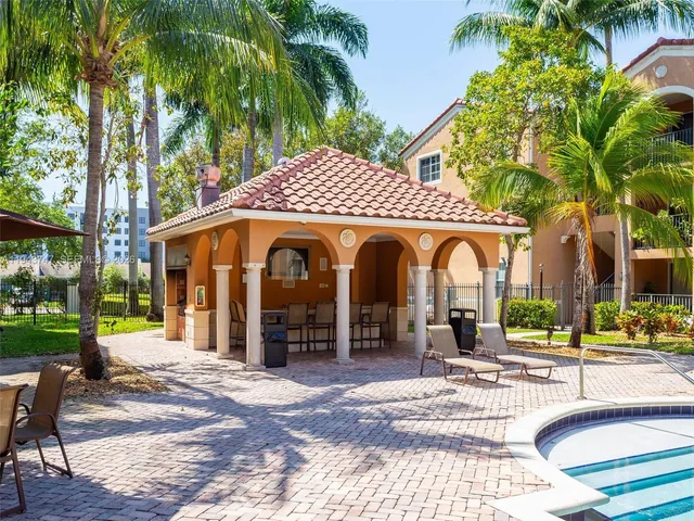 a view of a garden with a building and palm trees